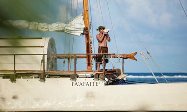 Polynésien sur une pirogue Polynésienne Fa'afaite avec un instrument nommé pu