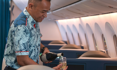 Cabin crew serving wine in Poerava Business Class